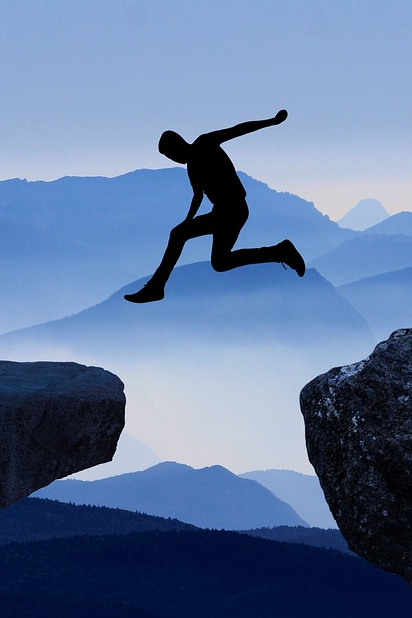 Man leaping from one rock to another
